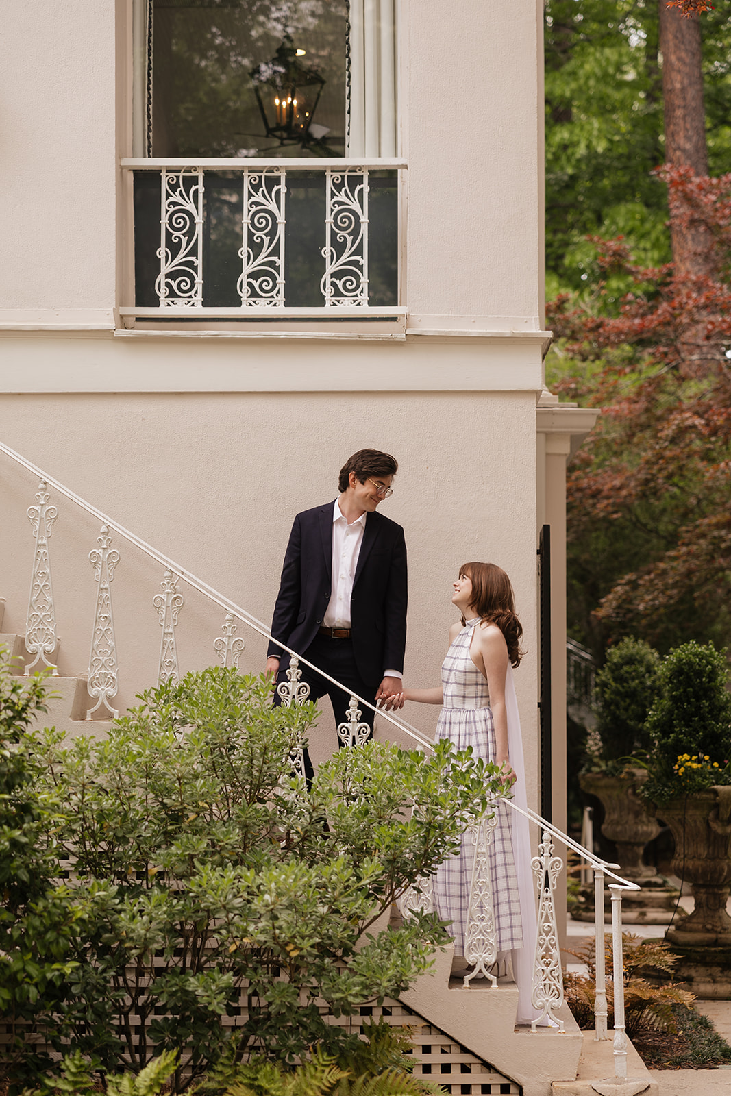 Elizabeth and Nicholas holding hands on a white staircase.